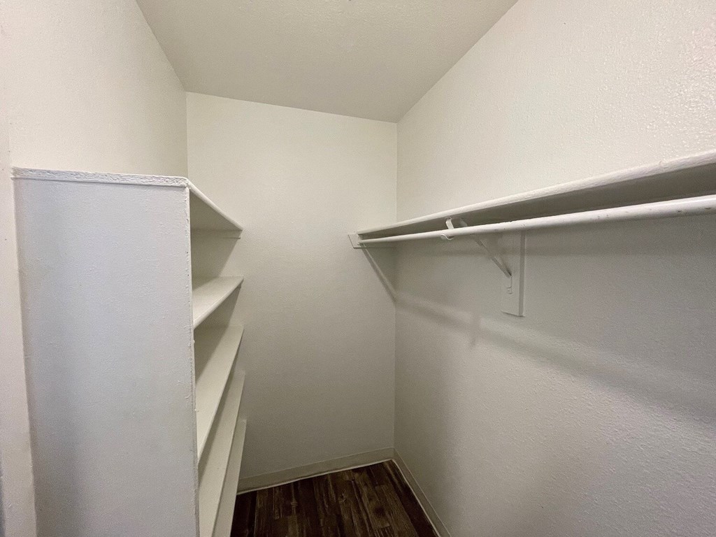 A white closet with shelves and a door.